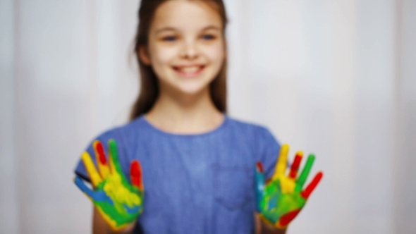Smiling Girl Showing Painted Hands alt