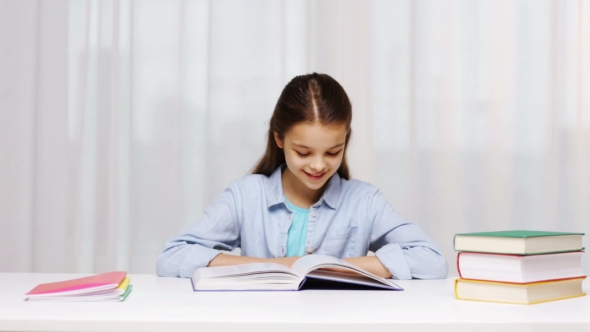 Happy School Girl Reading Book Or Textbook At Home