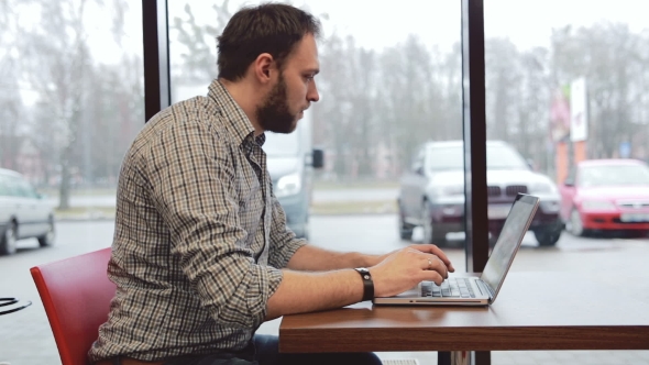 Man Working On Laptop In Cafe alt