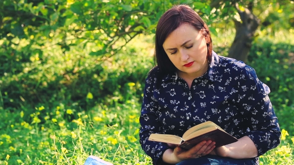 Attractive Woman Reading Book  In Park.