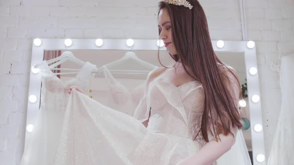 Happy Bride Trying on Sparkling Wedding Dress alt