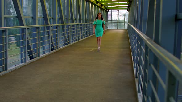 Front view of young woman in dress going pedestrian crossing. alt