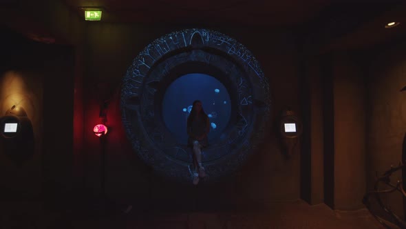 Girl Visiting the Dubai Aquarium She Sits Down and Looks Around alt