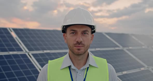 Portrait of Cheerful Male Engineer in Protective Helmet Looking To Camera. Handsome Man in Uniform alt