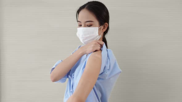 Young Asian Woman Showing COVID19 Vaccine Bandage Merrily alt