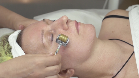 Cosmetologist Make Galvanotherapy Face Of Woman By Metal Roller In Beauty Saloon alt