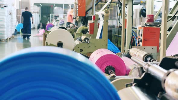 Factory Rolling Machines with Pieces of Polyethylene Foil on Them alt