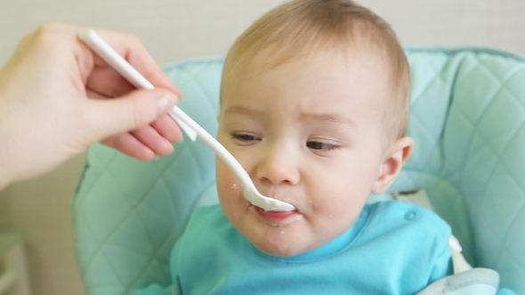 Mother Spoon Feeding A Boy  alt