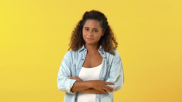 Young African American woman feeling sad and about to cry isolated on studio yellow background
