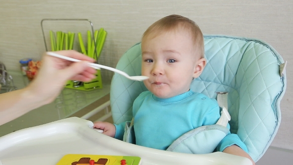 Mother Spoon Feeding A Boy  alt