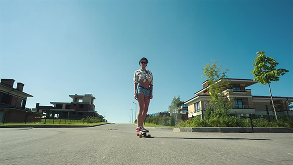 Woman Down The Road With Skateboard alt