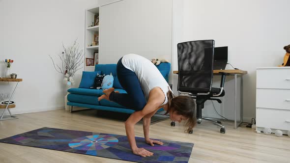 Young Woman Does Yoga At Home, Performs Arm Balance And Cobra Pose Exercise