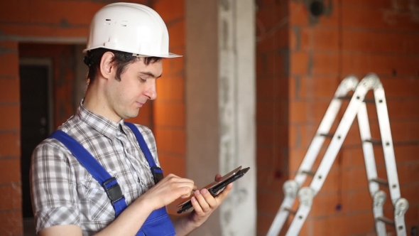A Civil Engineer Conducts Economic Calculations On The Tablet