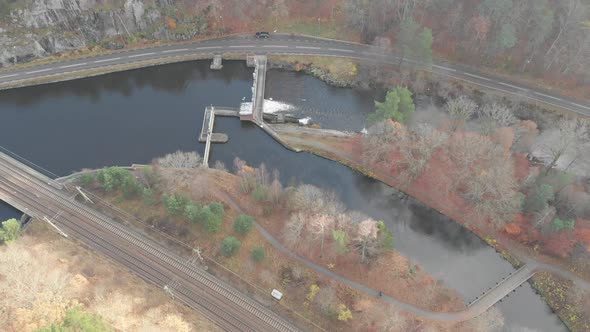 Scenic Water Canal With Small Bridge Next to Road Late Autumn Aerial
