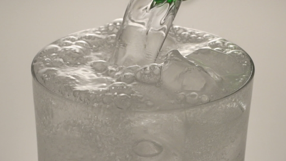 Sparkling Mineral Water Being Poured Into Glass From Green Bottle