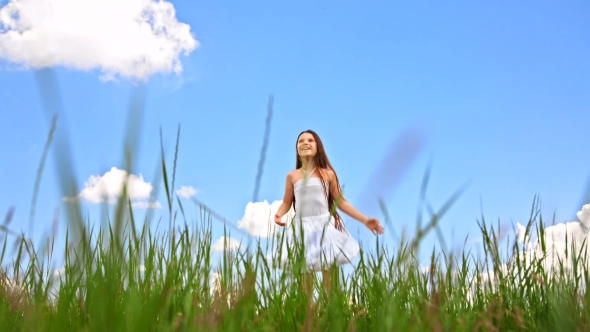 Happy Girl Jumping In Green Field