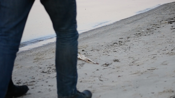 Legs Of Man And Woman Walking On The Beach Step For Step