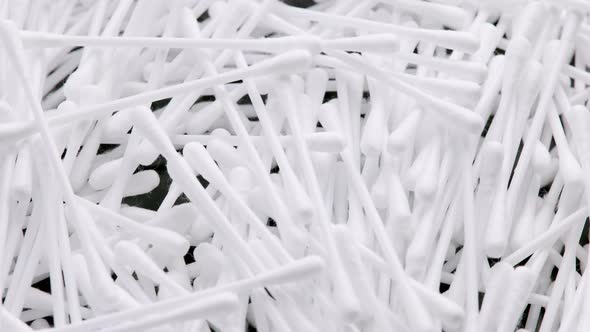 Pile of Qtips or Cottom Buds Slowly Rotating on Black Background alt