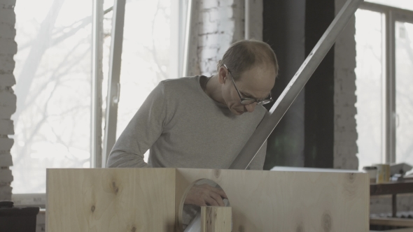 Carpenter Search Something Among Woodworking Materials. Hold Metal Balk In Hands alt