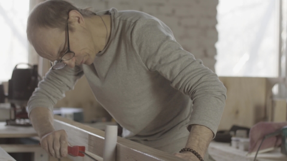 Carpenter Varnishing Long Wooden Board By Paint Roller. Process Of Treatment.  alt