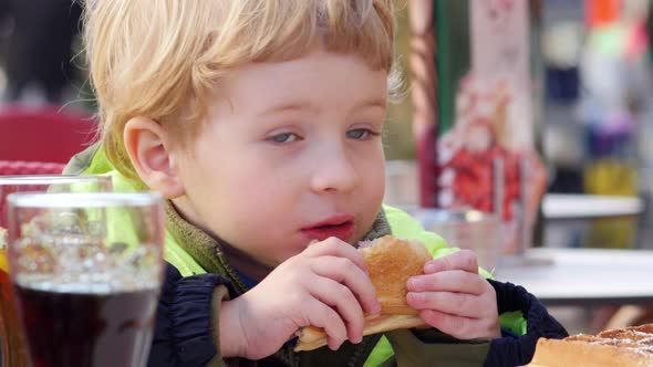 Young Blond Boy (3-4 Years Old) Eating Sandwich In Cafe