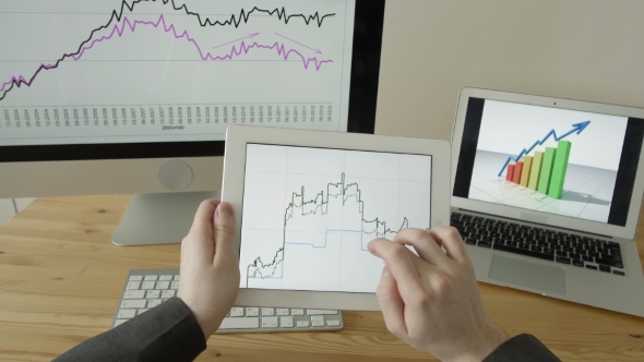 Experienced Businessman Looking At Financial Data With Graphics alt