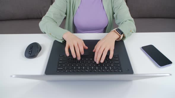 Entrepreneur woman typing text on notebook computer at home in 4k footage alt
