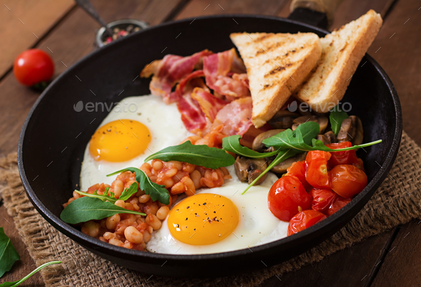English breakfast - fried egg, beans, tomatoes, mushrooms, bacon and toast