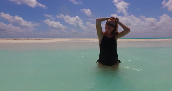 Modern smiling girls relaxing spending quality time at the beach on clean white sand alt