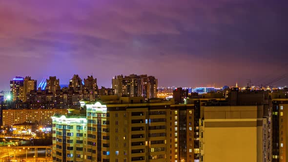 Night cityscape, Timelapse. Lights of buildings on the skyline. Cars lights on the streets alt
