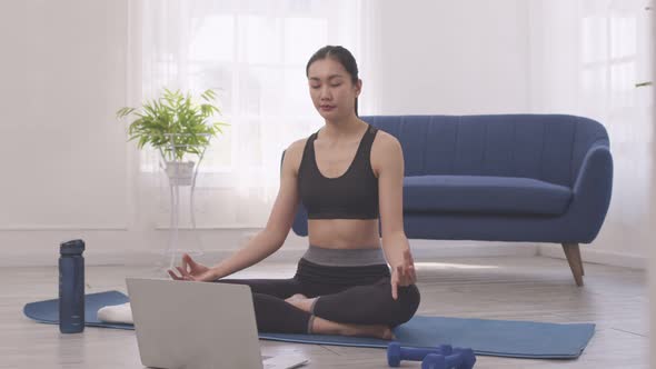 Asian woman does morning yoga, sitting in Easy position, Sukhasana posture, alt