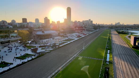 Sun sets over Hipodromo Argentino de Palermo horse racing track, spectators gathering alt