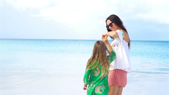 Little Girl and Young Mother on the Beach Hava Lot of Fun Together alt