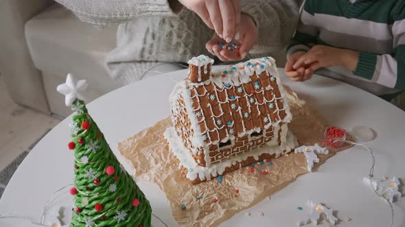 Little Boy with Mother Decorating Christmas Gingerbread House Together Family Activities and alt