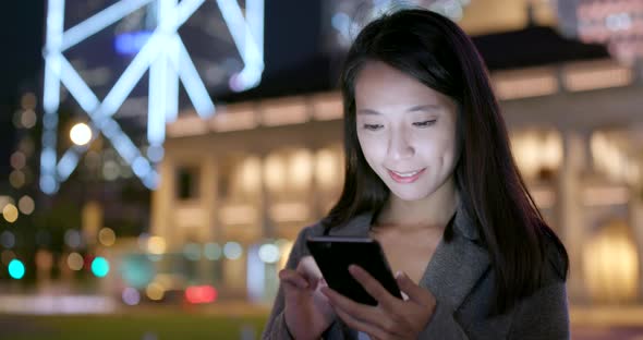 Businesswoman use of smart phone in city at night alt