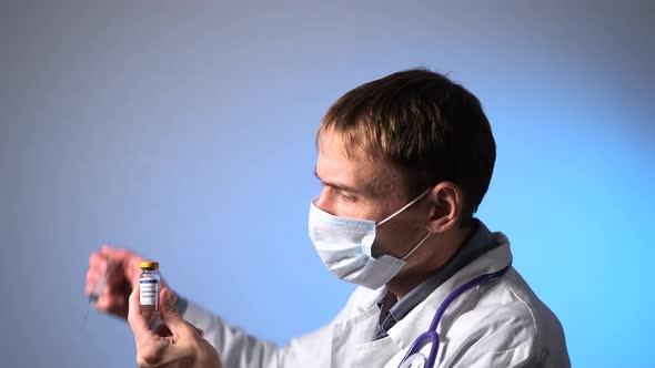 Male Doctor Drawing Up COVID19 Vaccine From Vial alt