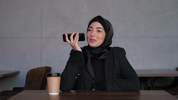 Business Muslim Woman in Hijab Leaves a Voice Message on the Mobile Phone