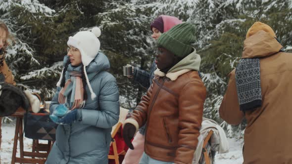 Young Friends Dancing at Campsite in Winter Forest alt