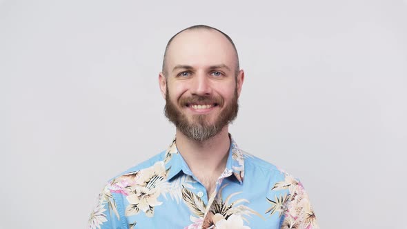 Portrait of a smiling man wearing hawaiian shirt over white background.