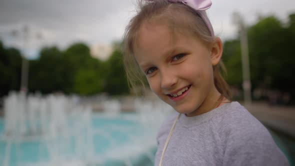 Girl With Yellow Balloon Near Fountain In City alt