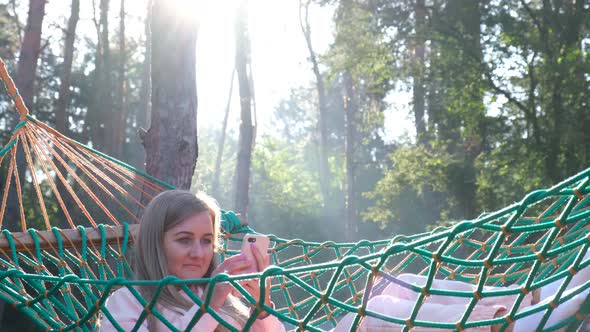 Young Man Resting in Comfortable Hammock at Green Garden alt