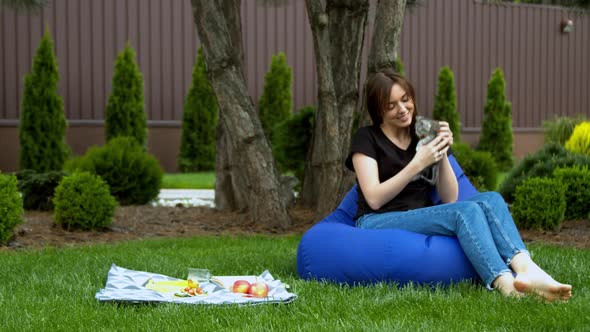 Woman Stroking Kitten in Garden