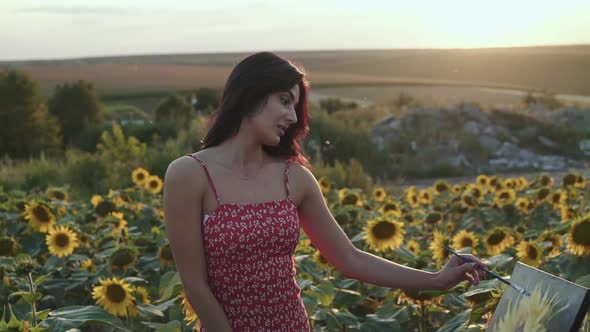 Beautiful View of Pretty Girl Painting a Sunflower Among Flower Field alt