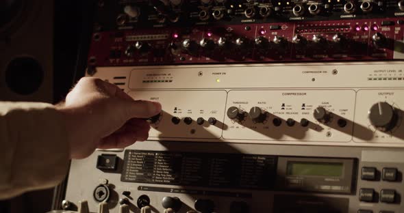 Man Turning Control Knob on Amplifier alt