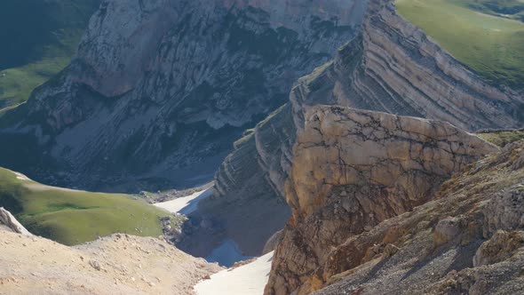 A mountain gorge high in the mountains. There are remnants of snow and a couple of lakes among alt