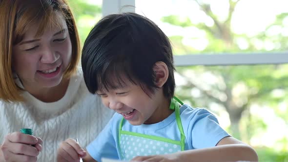 Cute Asian Child And Mother Painting Together alt