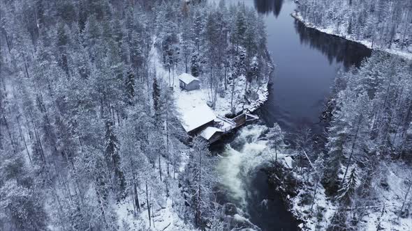 drone footage of a cabin in a snowy landscape in finland alt