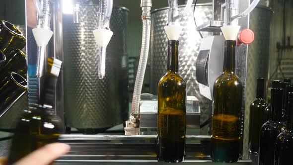 Filling Brown Glass Bottles with Wine By Machine in Winery alt
