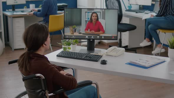 Immobilized Entrepreneur Talking with Coworker During Video Conference alt