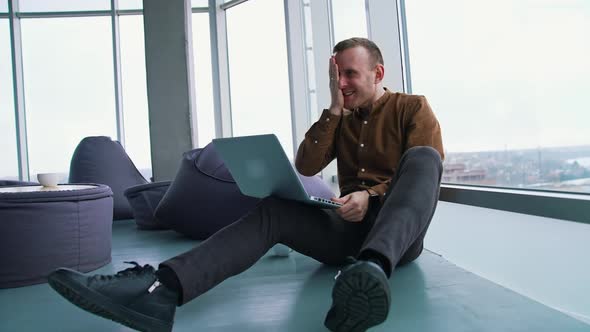 young man sitting on a floor with laptop computer. Work stress concept of man alt